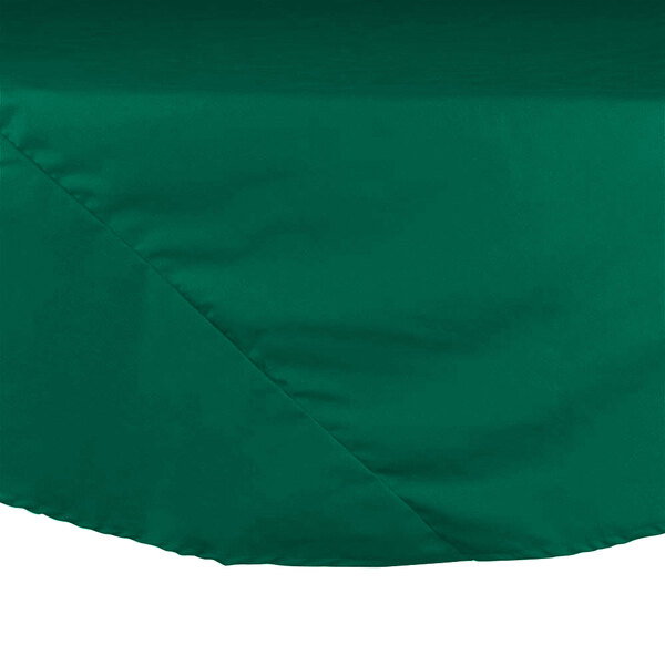 An Intedge green poly/cotton blend table cover with a large round top on a table.