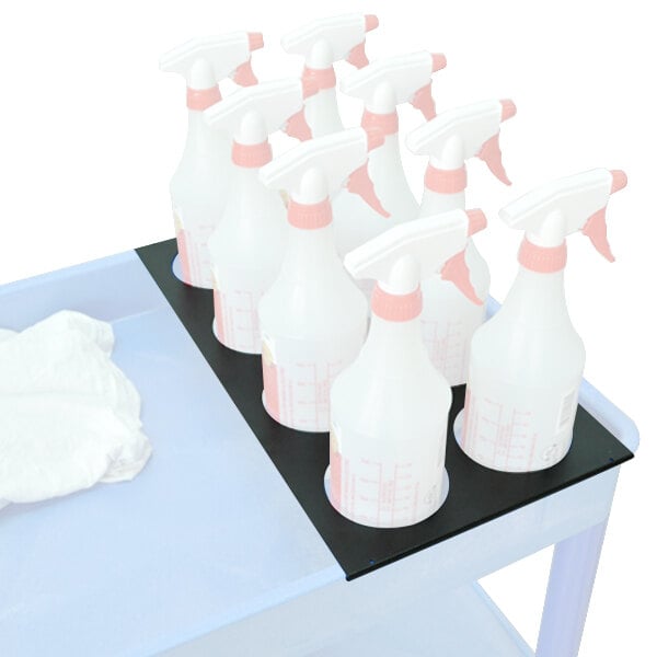 A white plastic tray with a black handle holding spray bottles and other cleaning products.