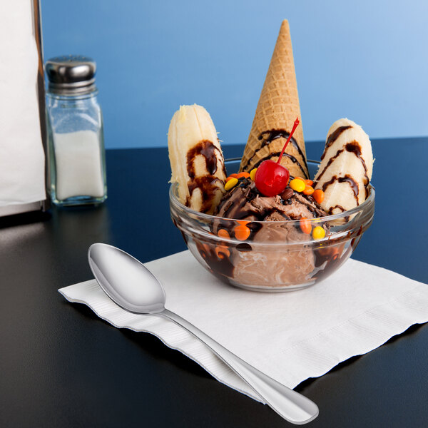 A bowl of ice cream with a Libbey stainless steel dessert spoon on a napkin.