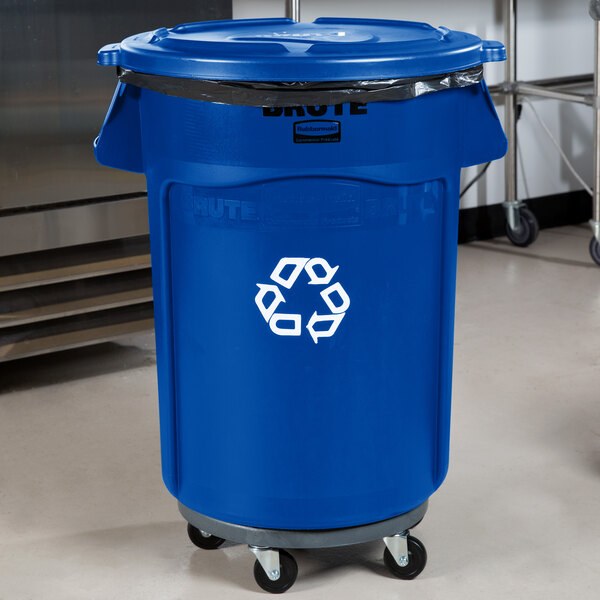 A blue Rubbermaid BRUTE trash can with a white recycle symbol on it and wheels.