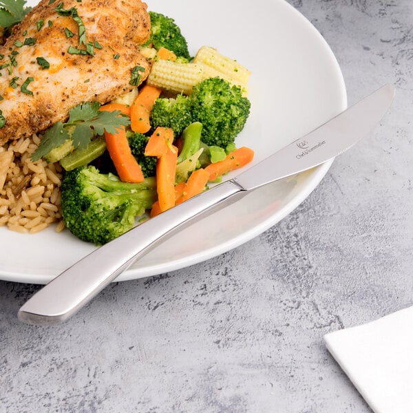 A plate of food with a Chef & Sommelier stainless steel dinner knife and fork with broccoli, carrots, and corn.