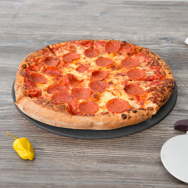 An Epicurean round wood fiber pizza board with a pepperoni pizza on it.