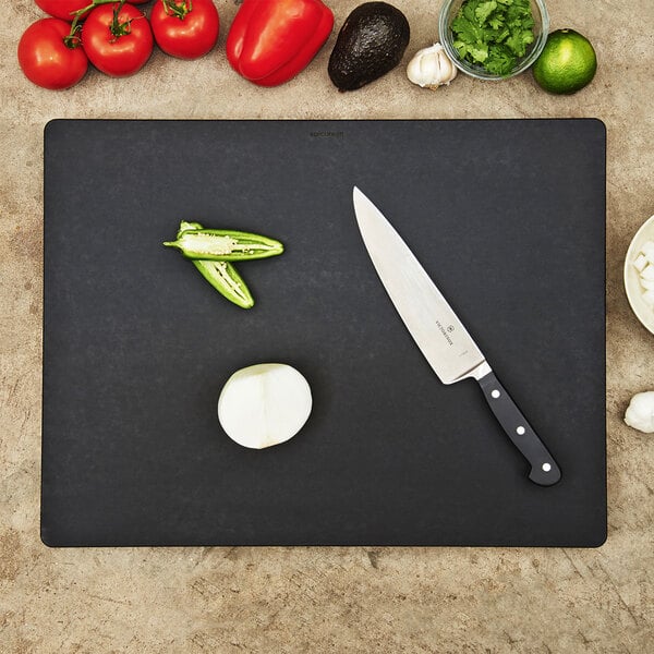 An Epicurean Richlite wood fiber cutting board with a knife and green vegetables on it.