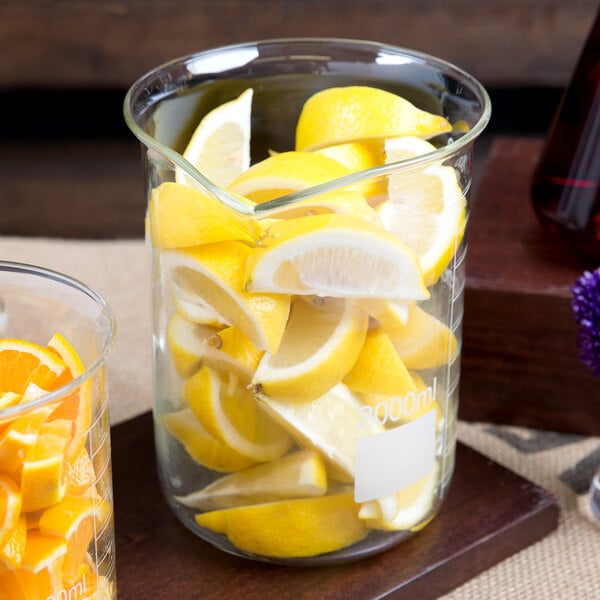 An American Metalcraft beaker glass filled with lemons and oranges.