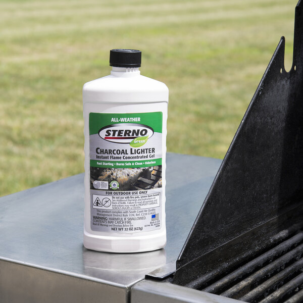 A white bottle of Sterno All-Weather Charcoal Lighter Gel on a grill.