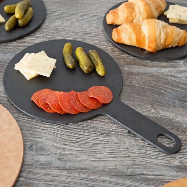An Epicurean slate wood fiber pizza board with a pizza on a table.