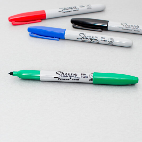 A group of Sharpie fine tip permanent markers in assorted colors on a white surface.