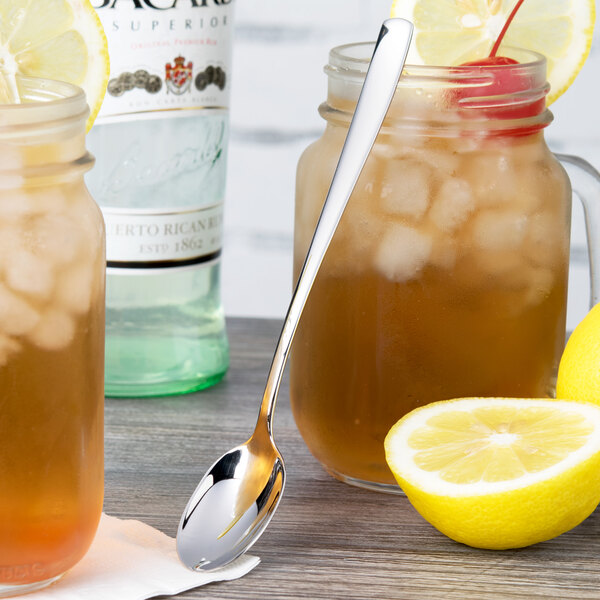 An Arcoroc stainless steel spoon in a glass jar of iced tea with lemon.