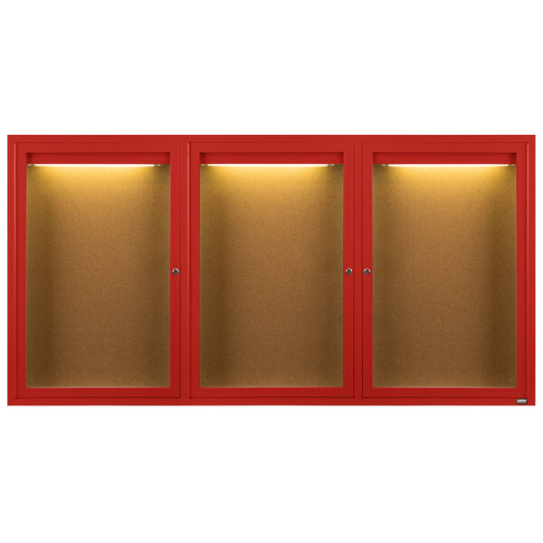 A red Aarco bulletin board cabinet with three glass doors and lights inside.