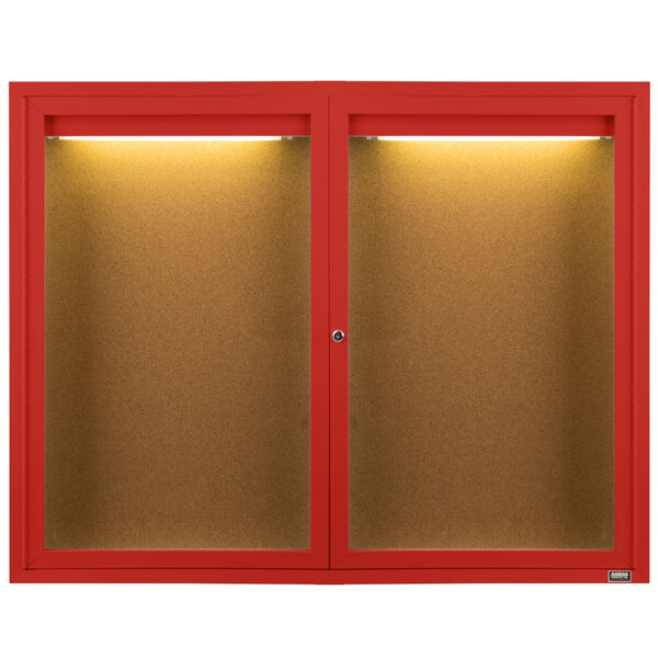 A red Aarco enclosed bulletin board cabinet with lights on it.