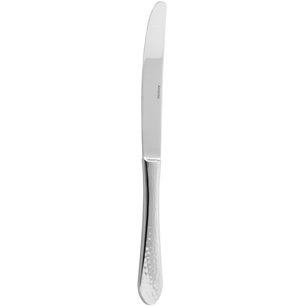 An Arcoroc stainless steel dinner knife with a textured silver handle.