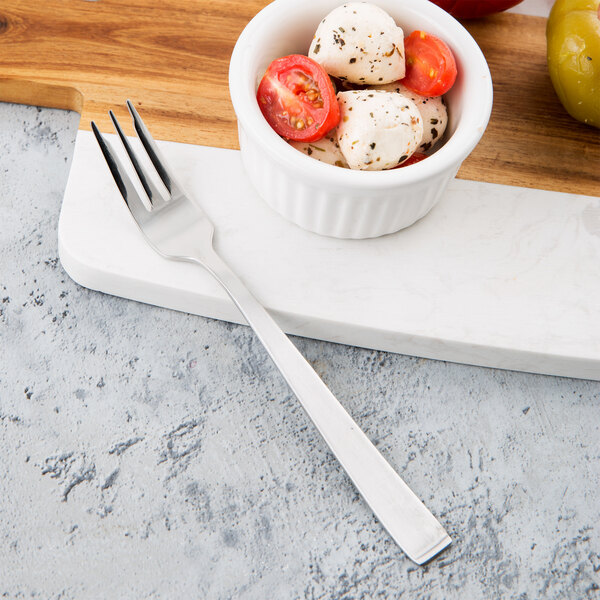 A Libbey stainless steel cocktail fork in a bowl of mozzarella and tomatoes.