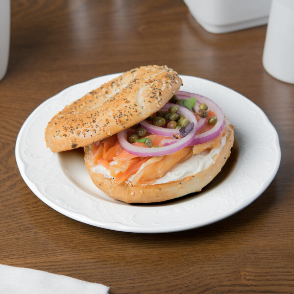 A Schonwald white porcelain plate with a bagel sandwich on it.