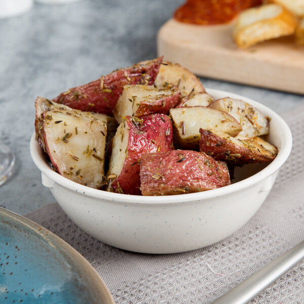 A bowl of red and white potatoes with herbs in a white Thunder Group San Marino nappie dish.