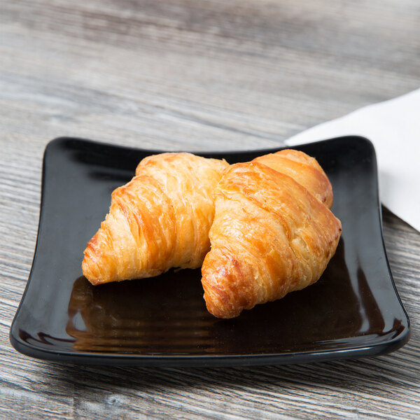 A plate of croissants on a black Milano square plate.