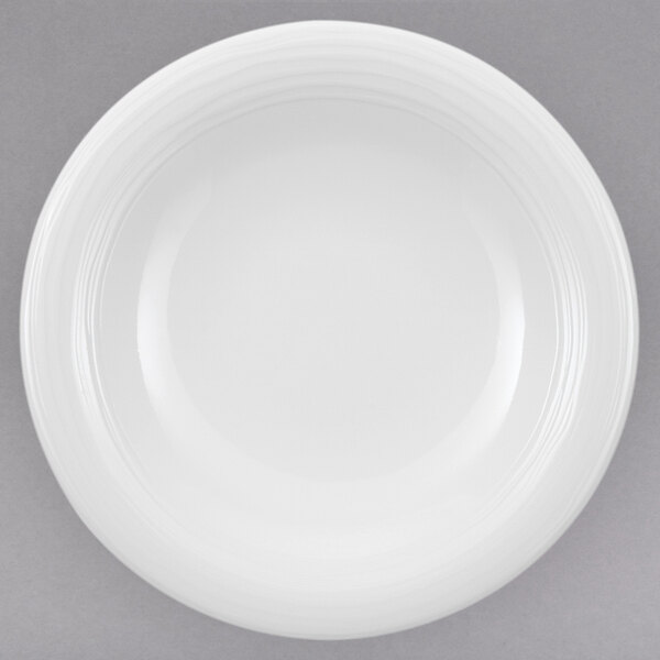 A close-up of a Villeroy & Boch white porcelain plate on a gray surface.