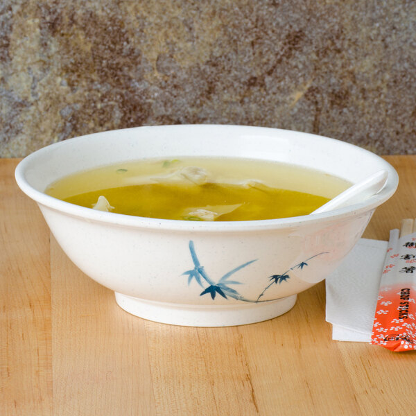 A Blue Bamboo melamine bowl of soup with a spoon.