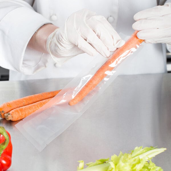 A person in white gloves using a VacPak-It chamber vacuum packaging bag to hold carrots.