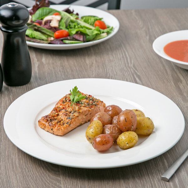 A white Villeroy & Boch porcelain plate with a piece of salmon and a salad.