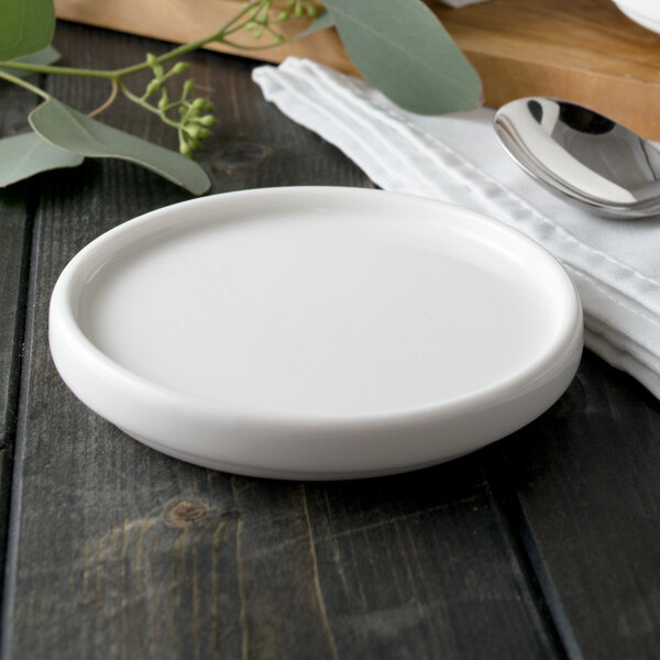 A white porcelain serving dish with a spoon on it.