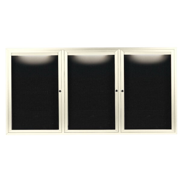 A white cabinet with three black glass doors.