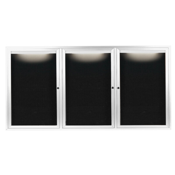 A white rectangular message center with three black glass doors.