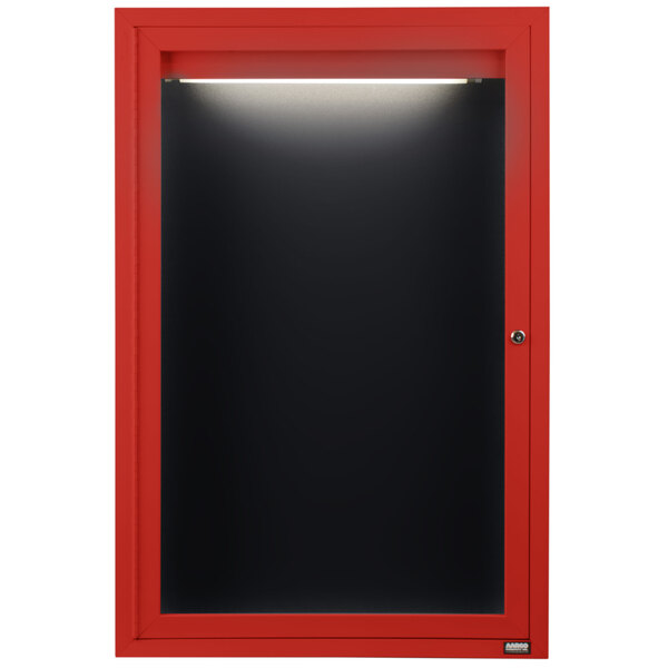 A red cabinet with a black door and a lighted black message board inside.