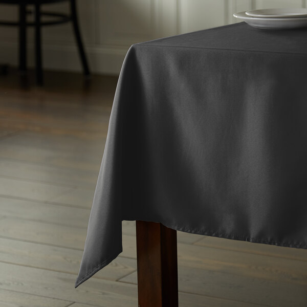 A table with a black Intedge rectangular tablecloth on it.