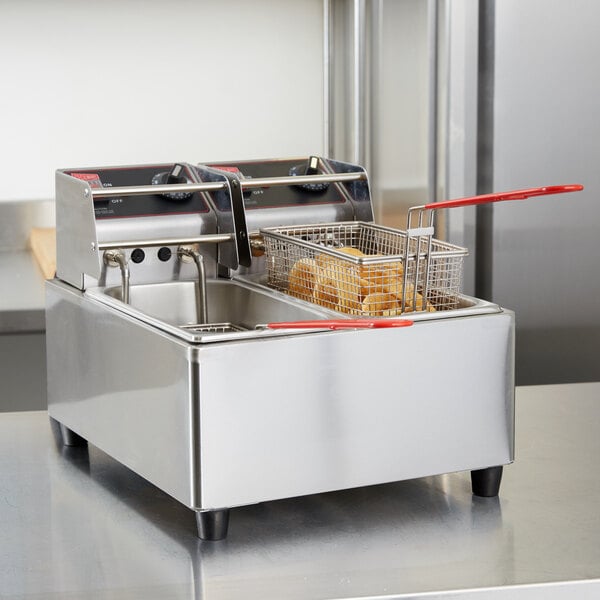 A Cecilware commercial countertop deep fryer with two fry baskets, one with a red handle.