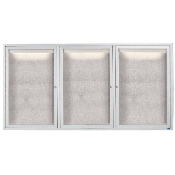 A white rectangular Aarco outdoor bulletin board cabinet with three glass doors and lights above each.