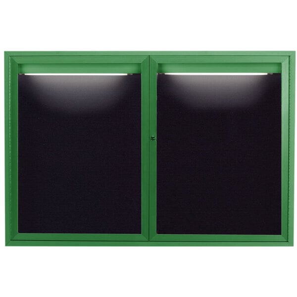 A green framed window with a black letter board inside and lights on top.