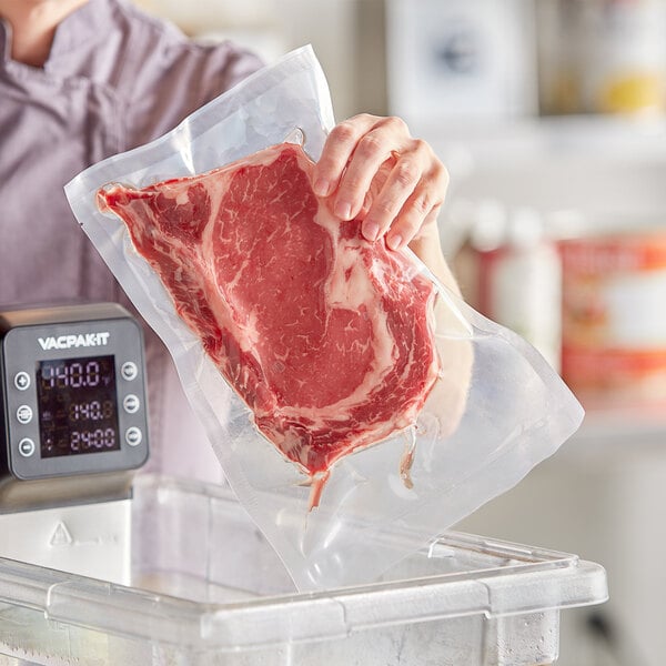 Vacuum packed meat in a VacPak-It 8" x 12" pouch on a counter in front of a digital timer.