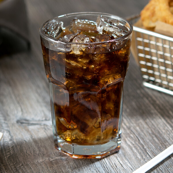 A glass of ice tea with ice cubes in an Anchor Hocking New Orleans beverage glass.