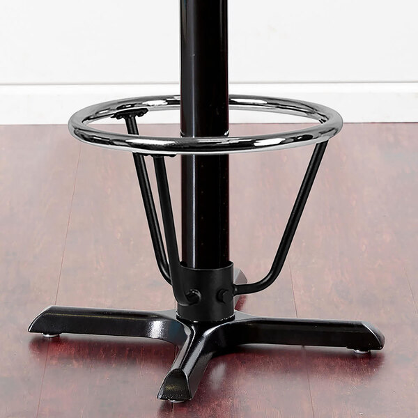 A Lancaster Table & Seating black cast iron bar height table base with a round foot ring around the column.