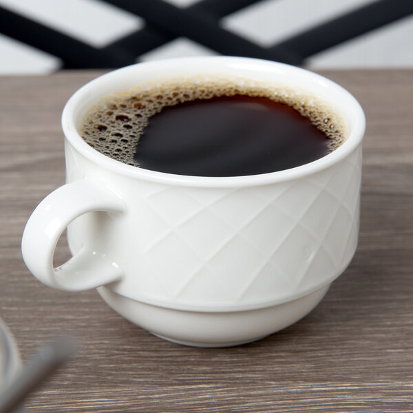A Villeroy & Boch white porcelain cup filled with coffee on a table.