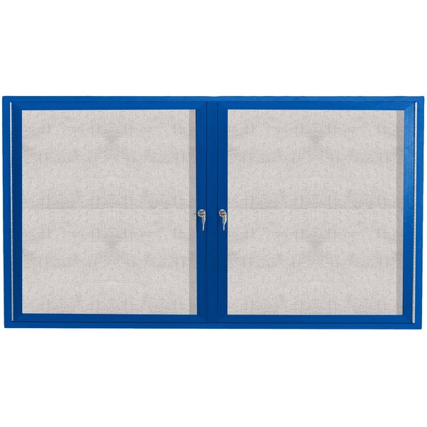 A blue cabinet with two hinged doors with white vinyl tackboard insets.