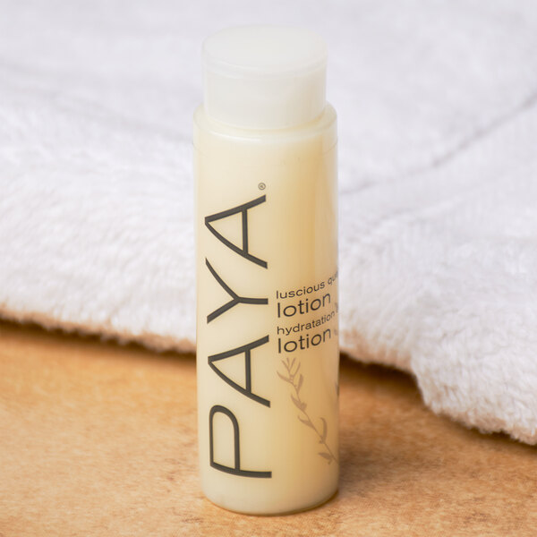 A close up of a small PAYA Papaya lotion bottle with a white cap and black text.