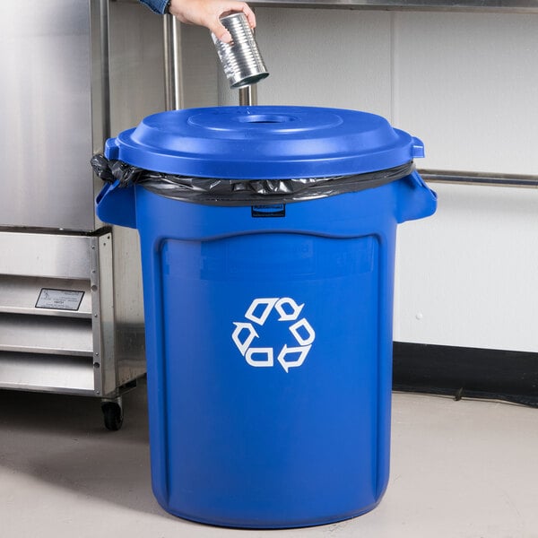 A person pouring water into a blue recycling bin with a Round Recycling Lid with Hole.