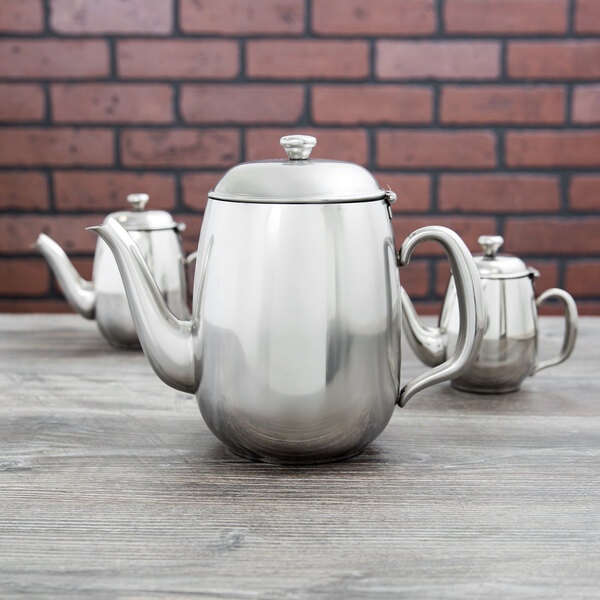 A close-up of a Vollrath stainless steel teapot with a lid.
