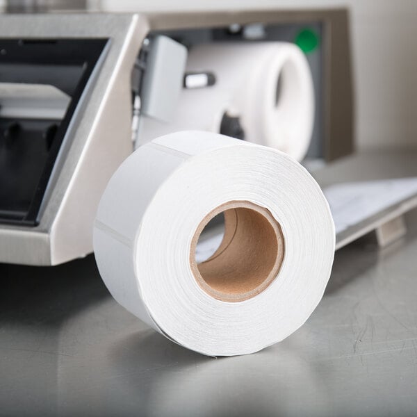 A roll of Tor Rey blank white thermal labels on a printer.