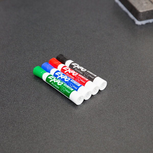 A set of Expo dry erase markers on a table.