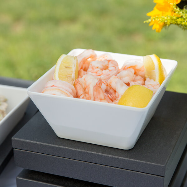 A white Vollrath melamine bowl filled with shrimp and lemon slices.