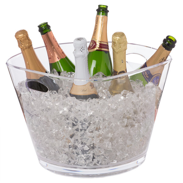 A Franmara customizable party bucket filled with champagne bottles on a table in a cocktail bar.