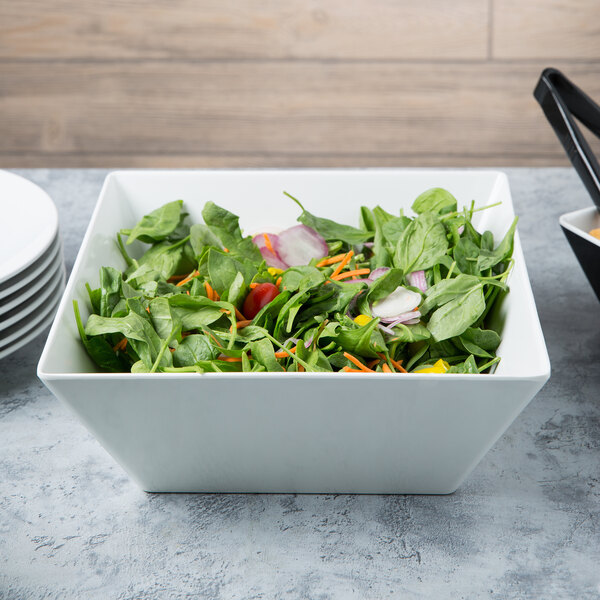A bowl of salad with vegetables in a white melamine bowl.