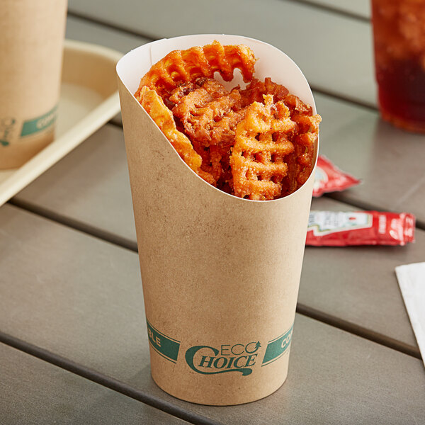 A Kraft paper cup filled with waffle fries on a table.