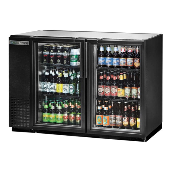 A black True back bar refrigerator with bottles of beer.