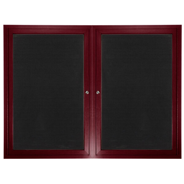 A cherry wood Aarco enclosed directory board with black felt panels on the doors.