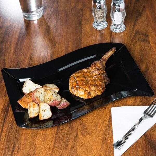 A black Fineline plastic plate with meat and potatoes on it.