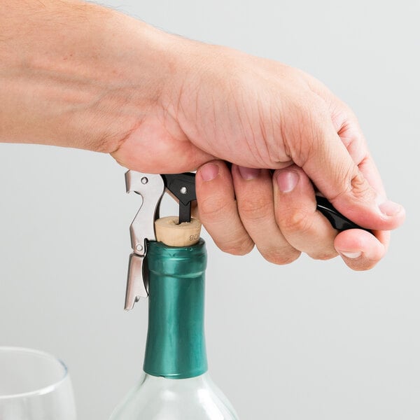 A hand using the Franmara Duo-Lever corkscrew to open a bottle of wine with a cork stopper.