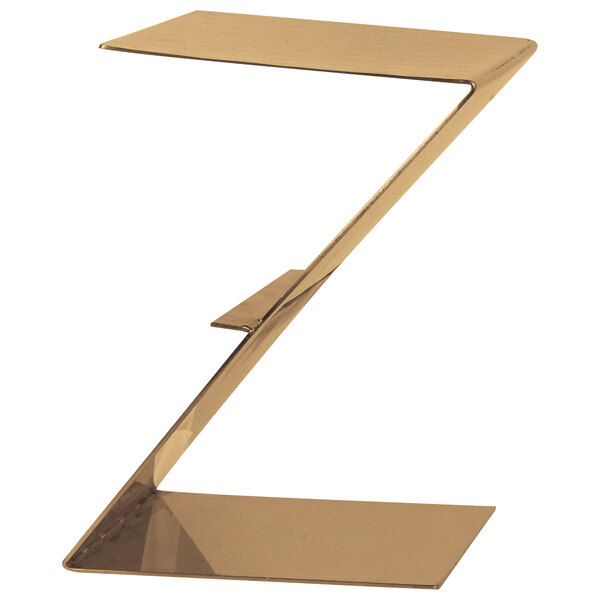 A bronze coated stainless steel Z-shaped riser on a table with a white background.